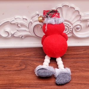 Detail of Christmas plush ornament with red green plaid hat and festive golden bell accessory