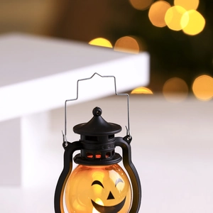 Détail d'une lanterne citrouille d'Halloween avec poignée noire et lumière LED
