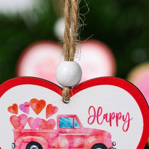 Close-up of heart-shaped wooden Valentine ornament with pink truck and red borders
