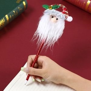 Roter Weihnachts-Kugelschreiber mit Weihnachtsmann-Figur und Glocke auf Notizblock
