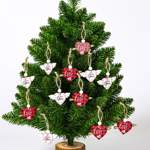 Detail of wooden heart ornaments with plaid patterns hanging on a green tree branch