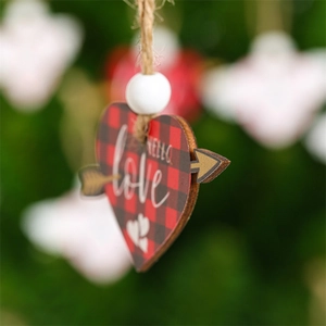 Detail of wooden heart ornament with red buffalo plaid pattern and love typography
