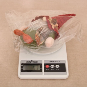 Close-up of a Christmas gnome doll on a digital scale showing 97g product weight