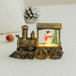 Vintage bronze Christmas train ornament with a glowing snow globe and snowman scene