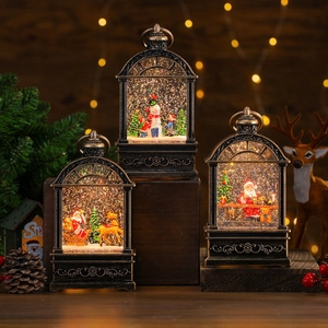 Retro bronze Christmas snow globe lanterns with Santa and snowman scenes on a dark wood table