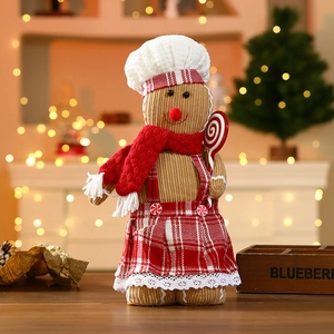 Detail of gingerbread plush doll with chef hat and candy cane in festive indoor setting