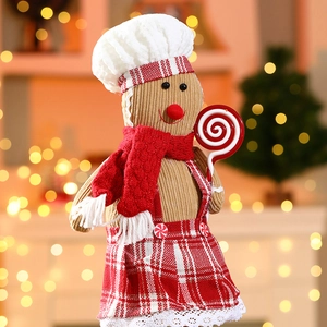 Detail of gingerbread man plush chef toy with candy cane and festive kitchen apron