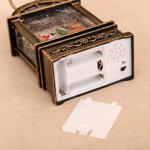 Detail of Santa Claus lantern base with battery compartment, speaker, and copper finish