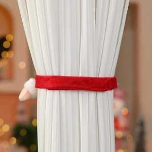 Détail d'embrasse de rideau de Noël en velours rouge avec pompon sur voilage blanc