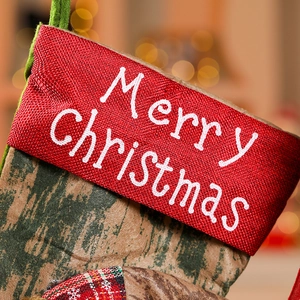Detail of Christmas stocking with Merry Christmas embroidery and red knit cuff