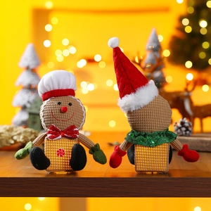 Close-up of two glowing plush gingerbread men with red hats for Christmas table decor