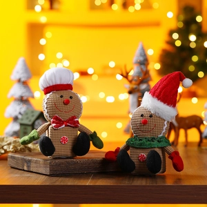 Close-up of glowing gingerbread plush dolls on a wooden tray in a cozy Christmas setting