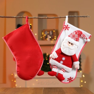 Détail de grandes chaussettes de Noël suspendues avec Père Noël 3D et flocons brodés