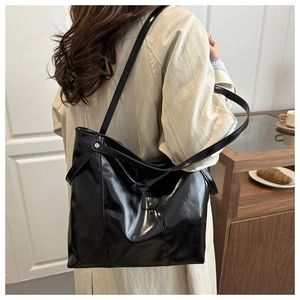 Detailed view of the black patent leather tote bag with a high-gloss finish for commuters