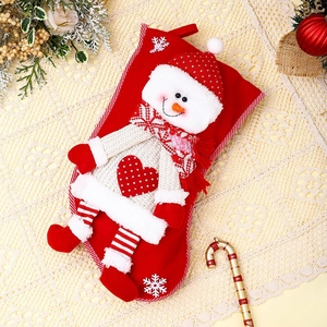 Détail de chaussette de Noël rouge avec bonhomme de neige 3D, jambe rayée et broderie de cœur