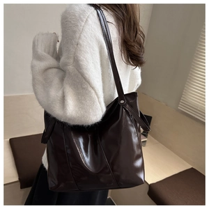 Vue macro de la texture en cuir verni brillant marron foncé sur un grand sac cabas