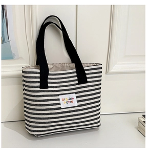 Close-up of thick canvas tote with black and white stripes and colorful brand label
