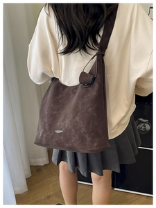 Vue détaillée du grand sac cabas en daim marron avec logo blanc imprimé sur la texture