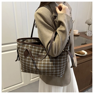 Detail of grey and yellow checkered tote bag with brown leather straps and drawstring