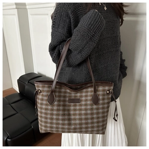 Detail of vintage plaid tote bag in green and brown with premium leather handles