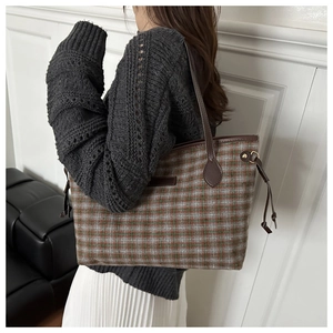 Detail of the large checkered tote bag showing wool fabric and leather drawstring trim