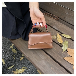 Vue détaillée du mini sac à main carré en cuir marron avec rabat et poignée