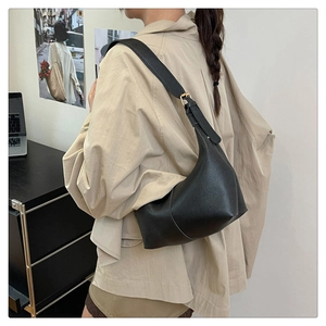 Detail of black lychee grain leather hobo bag with gold buckle on adjustable strap