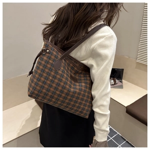 Detailed view of British style plaid tote bag with brown leather shoulder straps