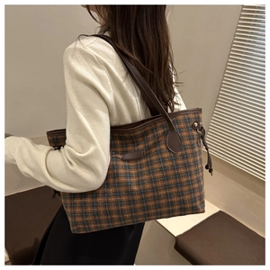 Detail of vintage plaid tote bag with brown leather handles and side drawstring