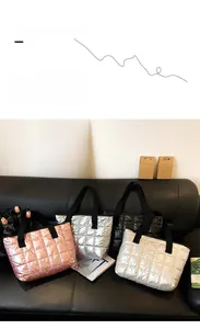 Detailed close-up of quilted space cotton tote bags in pink, silver, black and white