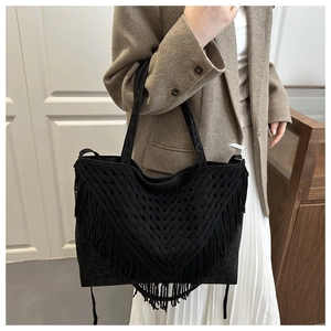 Detail of black tote bag with dark leopard pattern and elegant V-shaped woven tassels