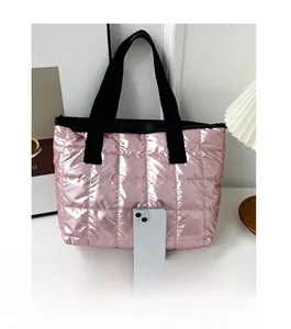 Pink metallic quilted tote bag shown with a smartphone for size reference and scale