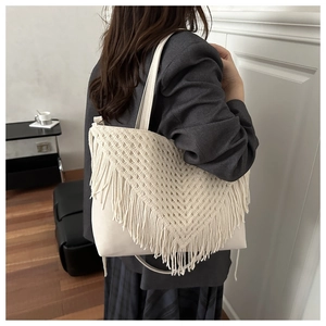 Detail of bohemian cream tote bag featuring intricate V-shaped fringe and tassels