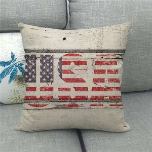 Detail of USA star and stripes linen pillow cover on a gray fabric sofa in home setting