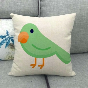 Gros plan d'une taie d'oreiller en lin avec un oiseau mignon sur un canapé gris
