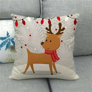 Close-up of linen Christmas pillow cover with cute reindeer and scarf on a sofa