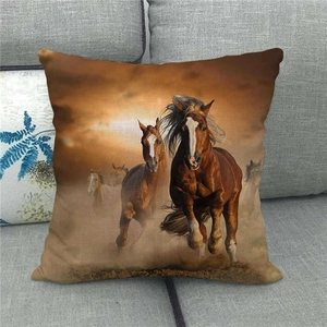 Close-up of running brown horses printed on a linen throw pillow cover on a grey sofa
