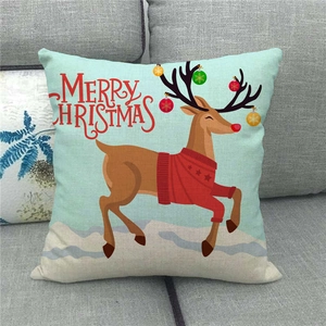 Christmas reindeer linen pillow cover with Merry Christmas text on a gray sofa