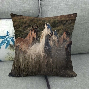 Linen cushion cover featuring galloping horses print displayed on a modern grey sofa