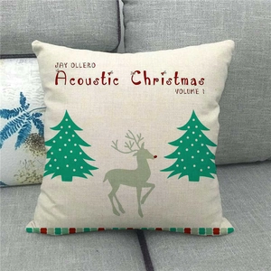 Detail of Christmas reindeer linen pillowcase with green trees on a grey sofa background