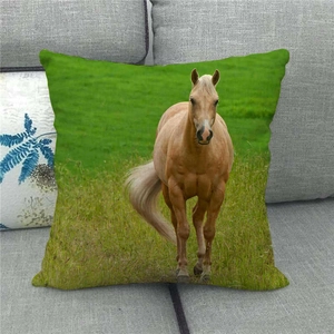 Detail of linen pillowcase with realistic brown horse print on a grey textured sofa