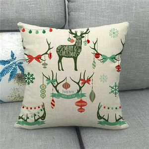 Detail of Christmas reindeer linen pillow cover on sofa with festive holiday ornaments