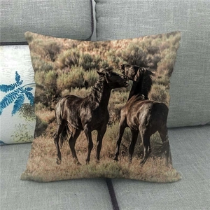 Linen cushion cover featuring two horses on a gray sofa in the African savanna