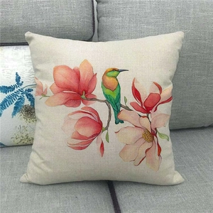 Detail of linen pillowcase featuring watercolor bird and magnolia flowers on a sofa