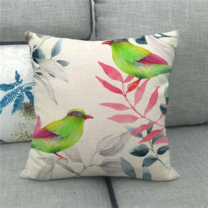 Close-up of bird and flower watercolor patterns on a natural linen cushion cover