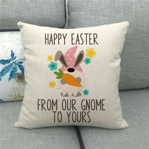 Close-up of Easter linen pillowcase with gnome and carrot print on a gray fabric sofa