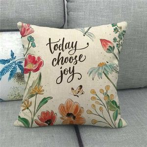 Linen pillow cover with floral wreath and 'today choose joy' text on a grey sofa