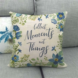 Linen pillowcase with blue floral wreath and Collect Moments not Things text on a sofa