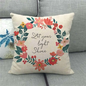 Christmas linen pillowcase with Let Your Light Shine floral wreath on grey sofa