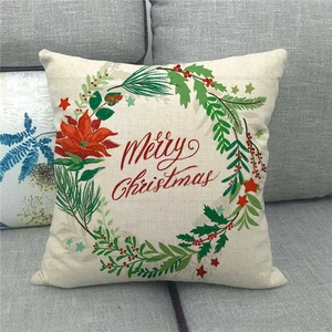 Close-up of linen pillow cover with Merry Christmas wreath on grey sofa